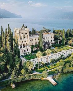 an aerial view of the palace and surrounding trees, with water in the foreground