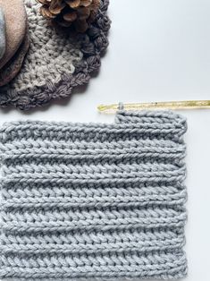 the crochet pattern is next to a knitted hat and a knitting needle