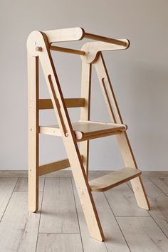 a wooden step stool sitting on top of a hard wood floor