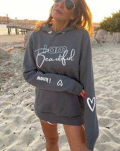 Beauty begins the moment you decide to be yourself!! Own it babes 🔥 One of a kind, limited edition ♥︎ Oversized grey hoodie sweatshirt♥︎ "I know" white graphic lower right sleeve♥︎ White "heart" graphic lower right sleeve♥︎ "I am Beautiful" white graphic on front♥︎ Hand drawn "heart" graphic in white lower left sleeveFIT:∙ Relaxed Fit∙ Soft supreme quality∙ Jersey lined hood∙ Flat, natural-colored drawcords∙ Front pouch pocket∙ 80% Cotton, 20% Poly, 100% Cotton Face∙ Model is 5'5", size 2, 34c, Trendy Gray Crew Neck Hoodie, Gray Graphic Print Hoodie For Spring, Trendy Gray Hoodie With Letter Print, Gray Graphic Print Hoodie For Loungewear, Trendy Gray Sweatshirt With Letter Print, Gray Letter Print Hoodie For Loungewear, Inspirational Hooded Sweatshirt With Letter Print, Casual Hooded Sweatshirt With Text Print, White Hooded Sweatshirt With Sublimation Print