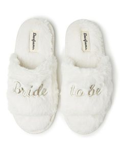 white slippers with bride to be written on the front and back, in faux fur