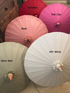 four umbrellas with different names on them sitting in front of a dresser and drawers