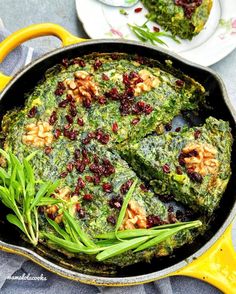 a pan filled with spinach and other food on top of a blue table cloth