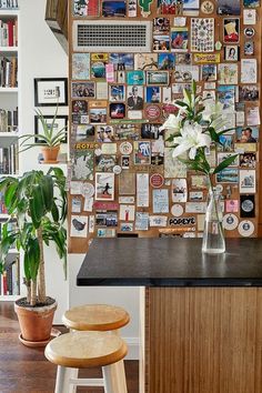 there is a vase with flowers in it on the counter next to two stools