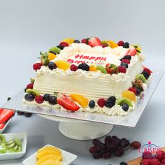 a birthday cake with fresh fruit on it