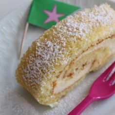 a piece of cake sitting on top of a white plate next to a pink fork