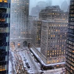 a city street filled with lots of traffic and tall buildings covered in snow at night