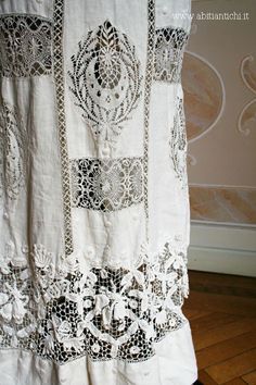 a white curtain with black and white lace on the bottom is hanging in front of a wooden floor