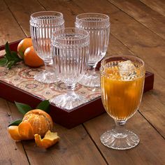 an assortment of glasses and oranges on a tray