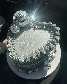 there is a cake that has been decorated with disco balls and the words it's girl