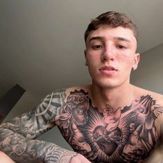 a man with tattoos on his chest and arms