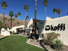 the exterior of an office building with palm trees in front of it and a sign that says elkoffi