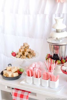 a dessert table with strawberries, marshmallows and other treats on it