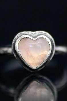 A glowing rose quartz heart cabochon is bezel set atop an ancient style round ring band. Fabricated from sterling silver with hammered and organic texturing all over. Oxidized and rubbed back for a dark patina in recesses. Each is unique and hand crafted one at a time by the artist, Miche McClendon, in her Laguna Beach studio/gallery. Rose quartz is known as the crystal of romance, sensitivity, empathy and passion. Please specify ring size in order or in a message. Each piece comes ready to gift Glowing Rose, Rose Quartz Wedding, Witch Ring, Beach Studio, Pink Witch, Heart Wedding Rings, Gold Moon Necklace, Festival Earrings, Rose Quartz Jewelry