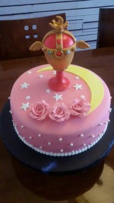 there is a pink cake with stars and a crown on top