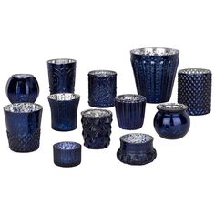 a group of blue glass vases sitting next to each other on a white background