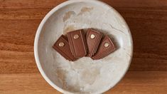 four pieces of chocolate in a white bowl