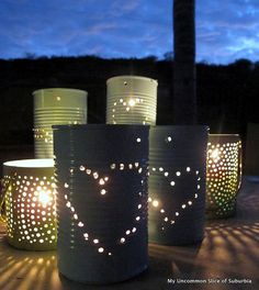 some tin cans with lights on them and the words, how to make a lantern with a recycled tin can