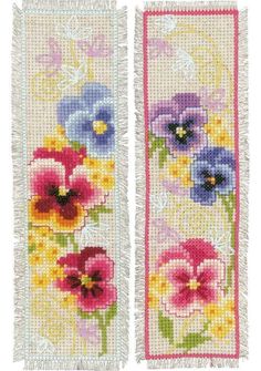 two cross stitch bookmarks with colorful flowers on the front and back covers, one is white