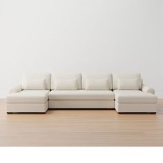 a white couch sitting on top of a hard wood floor next to a white wall