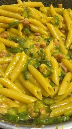 a pan filled with pasta and vegetables covered in sauce