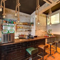 a bar with several stools and lights hanging from the ceiling