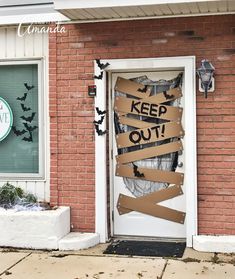 a door decorated with cardboard taped to the side and words that read, keep out