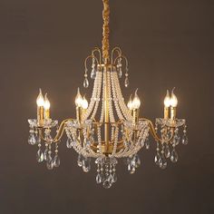 a gold chandelier with crystal drops hanging from it's center and sides