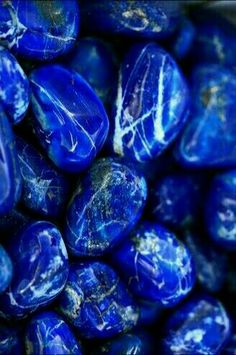 blue marbles are piled up together in this close - up photo, which is very dark