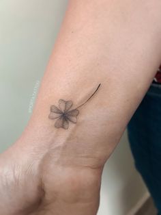 a small four leaf clover tattoo on the wrist