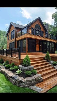 a large wooden house sitting on top of a lush green field