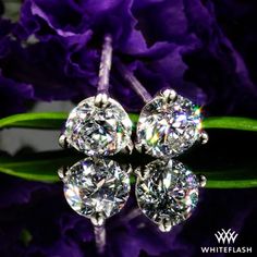 three stone diamond stud earrings with purple flowers in the background