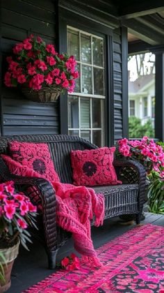 a porch with pink flowers and wicker furniture