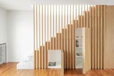 an empty room with wood slats on the wall and wooden flooring in front of it