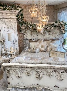 an old fashioned white bed with chandelier and pillows