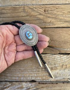 Handsome Turquoise bolo tie...1 15/16" tall by 1 1/2" wide at the widest spot, handmade and signed in sterling silver 925 by a Navajo silversmith with a beautiful Golden Hills turquoise stone that I cut...the cord is a 5mm wide 48" long braided black leather and the bolo tips are handmade also in sterling silver 925.. the bolo has gorgeous stamping!! Southwestern Sterling Silver Bolo Tie As Gift, Handmade Sterling Silver Bolo Tie As Gift, Artisan Silver Lariat Bolo Tie, Handmade Lariat Bolo Tie For Rodeo, Adjustable Southwestern Silver Turquoise Necklace, Handmade Bolo Ties As Unique Gifts, Southwestern Sterling Silver Bolo Tie, Southwestern Style Sterling Silver Bolo Tie, Artisan Turquoise Bolo Ties With Concho