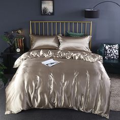 a bed with gold sheets and pillows in a room