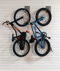 an upside down bike hanging on the side of a garage wall with two bikes attached to it