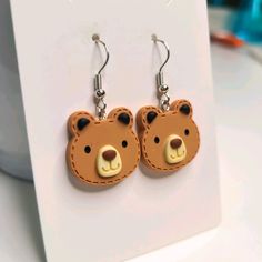 a pair of earrings with a brown bear on it