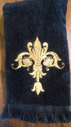 a black towel with gold fleur de lis on it