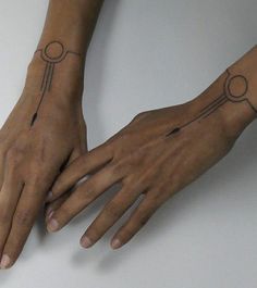 two hands that have tattoos on them