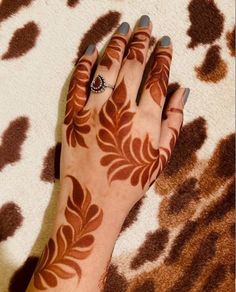 a woman's hand with henna tattoos on it