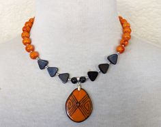 This necklace is a part of a series that was inspired by some beautiful Coconut shell pendants I found in various colors. These necklaces were so much fun to make and would be the perfect "pop of color" to brighten-up any outfit!        Materials: Orange Swirl Glass Beads, Black Onyx Triangle Beads, Metallic Silver-Plated Glass Beads, Silver-plated clasp, Coconut Shell Pendant Length: Approx 16 3/4" from end to end, 2 1/2" extender chain, Pendant 1"W  X  2 1/2" W   If you have any questions or concerns please feel free to contact me! ♥ ♥ ♥ ♥ ♥ ♥ ♥ ♥ ♥ ♥ ♥ ♥ ♥ ♥ ♥ ♥ ♥ ♥ ♥ ♥ ♥ ♥ ♥ ♥ ♥ ♥ ♥ ♥ ♥ ♥ ♥ ♥ Visit my shop here: http://www.etsy.com/shop/GlobalBeadWorks ♥ ♥ ♥ ♥ ♥ ♥ ♥ ♥ ♥ ♥ ♥ ♥ ♥ ♥ ♥ ♥ ♥ ♥ ♥ ♥ ♥ ♥ ♥ ♥ ♥ ♥ ♥ ♥ ♥ ♥ ♥ ♥ Orange Choker, Triangle Beads, Choker Necklace Black, Black Pendant Necklace, Necklace Orange, Halloween Necklace, Black Pendant, Black And Orange, Coconut Shell