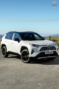 a white toyota rav parked on the side of a road