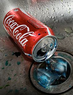 a can of coca - cola sitting on top of a sink with water droplets around it