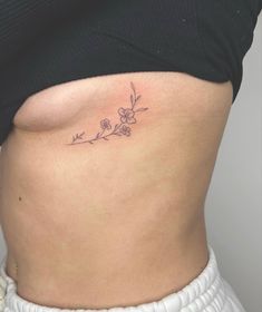 flower tattoo @chiko.tattoo Family Tiny Tattoo Ideas, Tiny Tattoos On Ribs, Reinvent Yourself Tattoo, Dainty Flower Tattoos Rib, Fine Line Ribcage Tattoo, Cute Tattoos Under Breast, Hip Tatoos Woman, Tattoo Around Breast, Under Rib Tattoos For Women