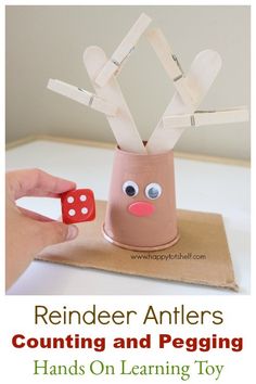 a hand holding a red dice with the words reindeer antlers counting and pegging hands on learning toy