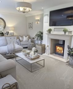 a living room filled with furniture and a flat screen tv mounted on the wall above a fire place