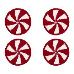 three red and white crocheted coasters with candy cane designs on each side