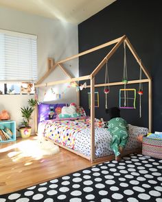 a child's bedroom with a bed and toys on the floor in front of it